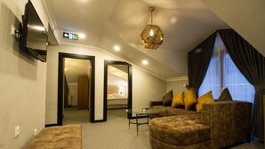 Un salon moderne avec un canapé d’angle, une petite table basse et un téléviseur fixé au mur.