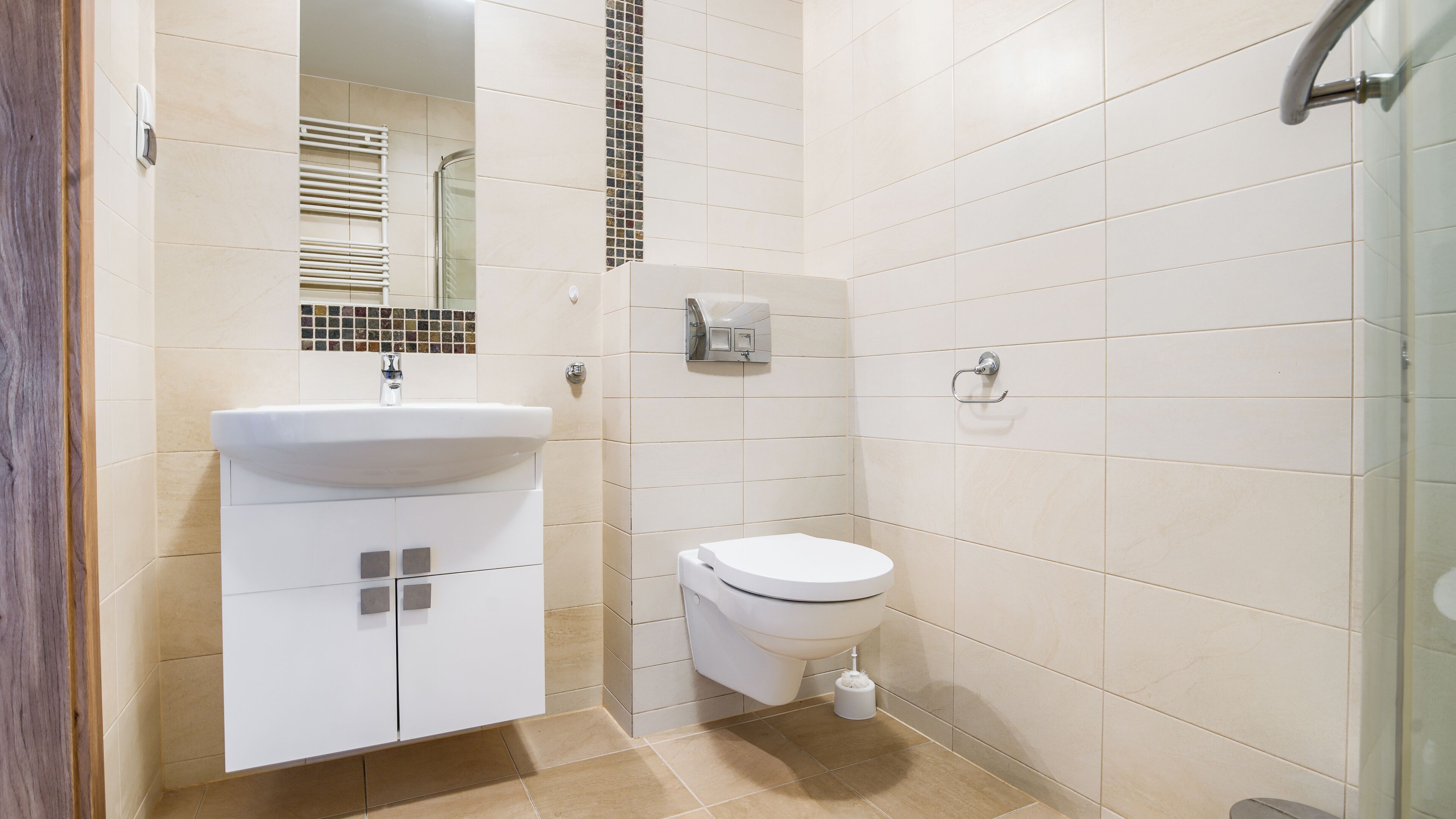 A bathroom with a sink, toilet, and a glass shower enclosure.