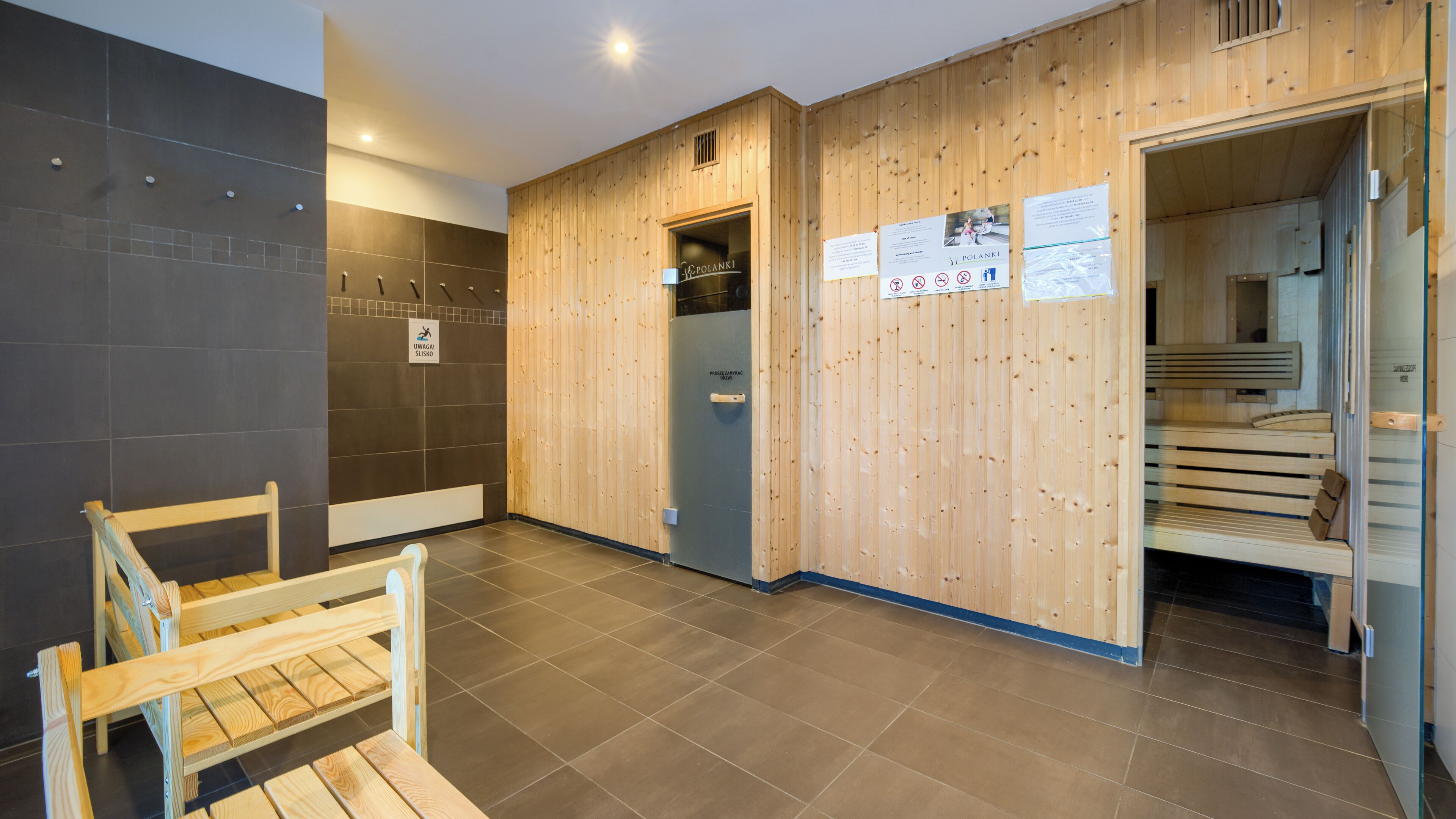 Un área de spa moderna con paredes de madera, una sauna y un banco de madera.