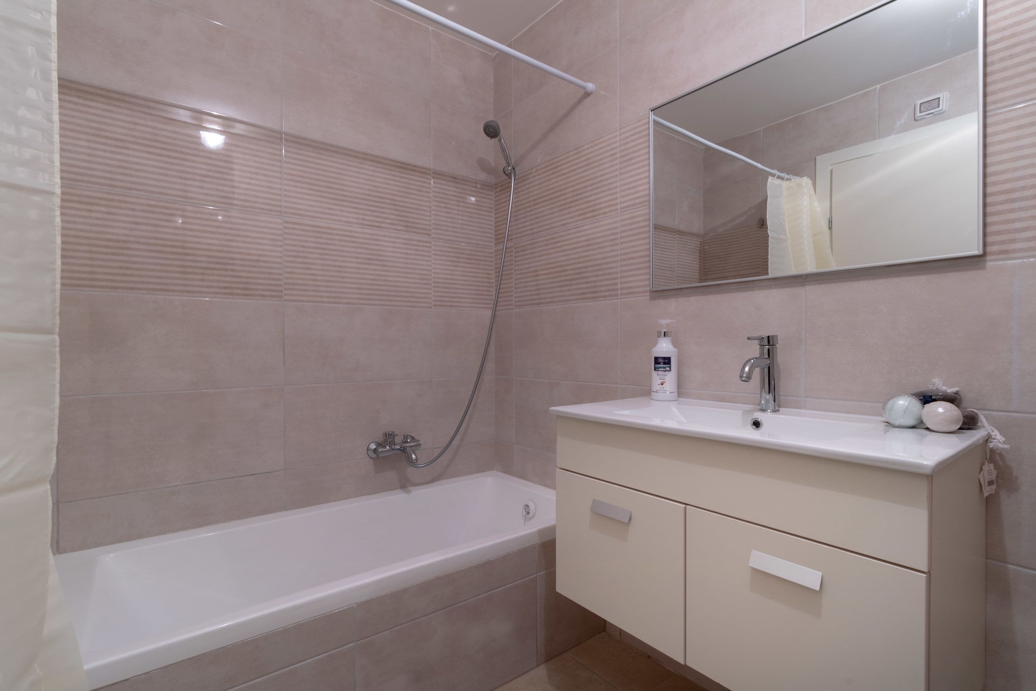 Un bagno moderno con vasca, doccia, lavandino e specchio.