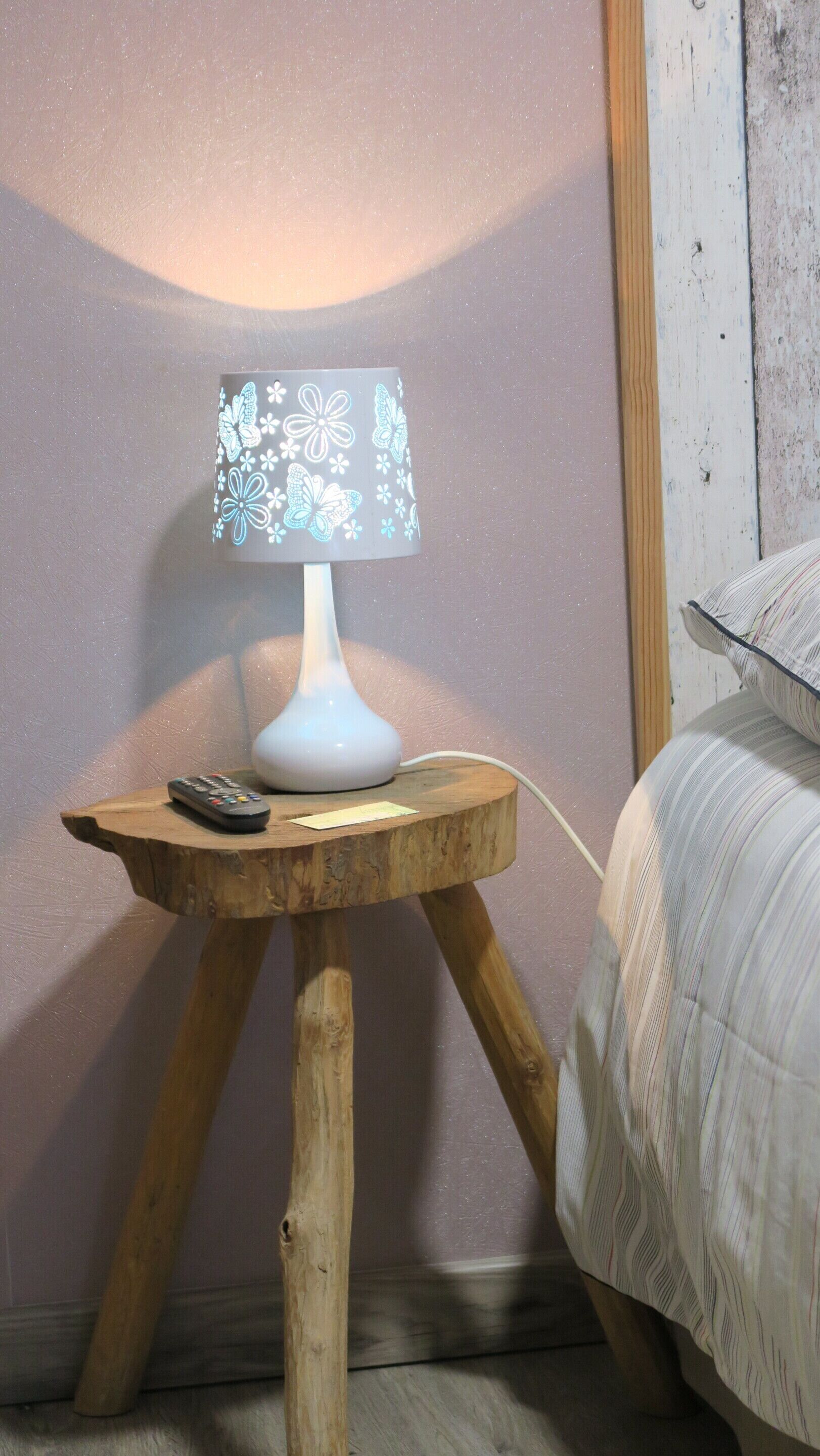Un comodino con una lampada, un telecomando e un cavo di alimentazione.