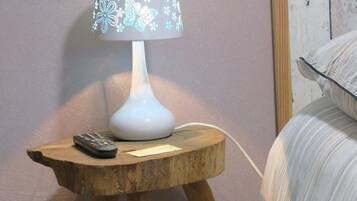 Un comodino con una lampada, un telecomando e un cavo di alimentazione.