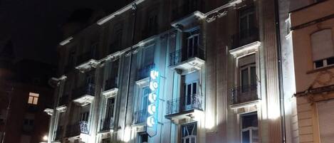 A building with a sign that reads 'ESCURIAL' and a blue bicycle rental sign.