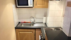 A compact kitchen with a microwave, sink, and stove. - North Circular Studios 2 (Dublin)