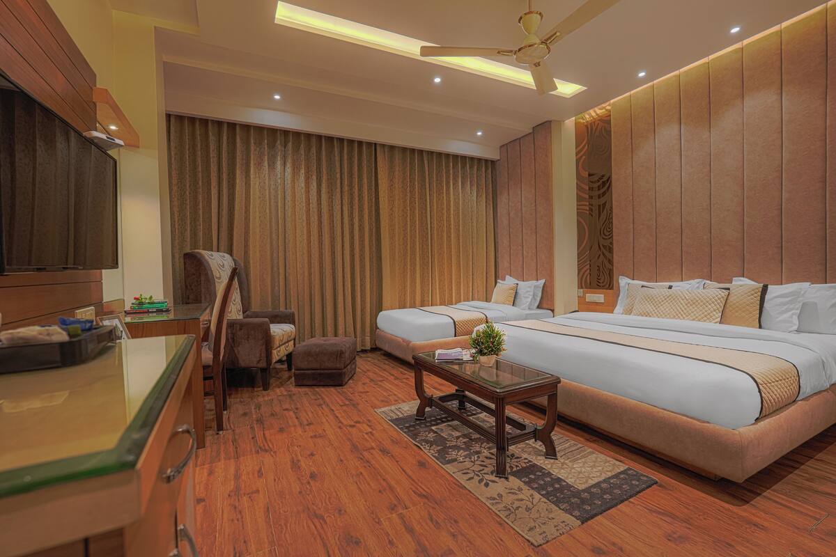 A hotel room with a bed, two bedside tables, a chair, a desk, and a ceiling fan.