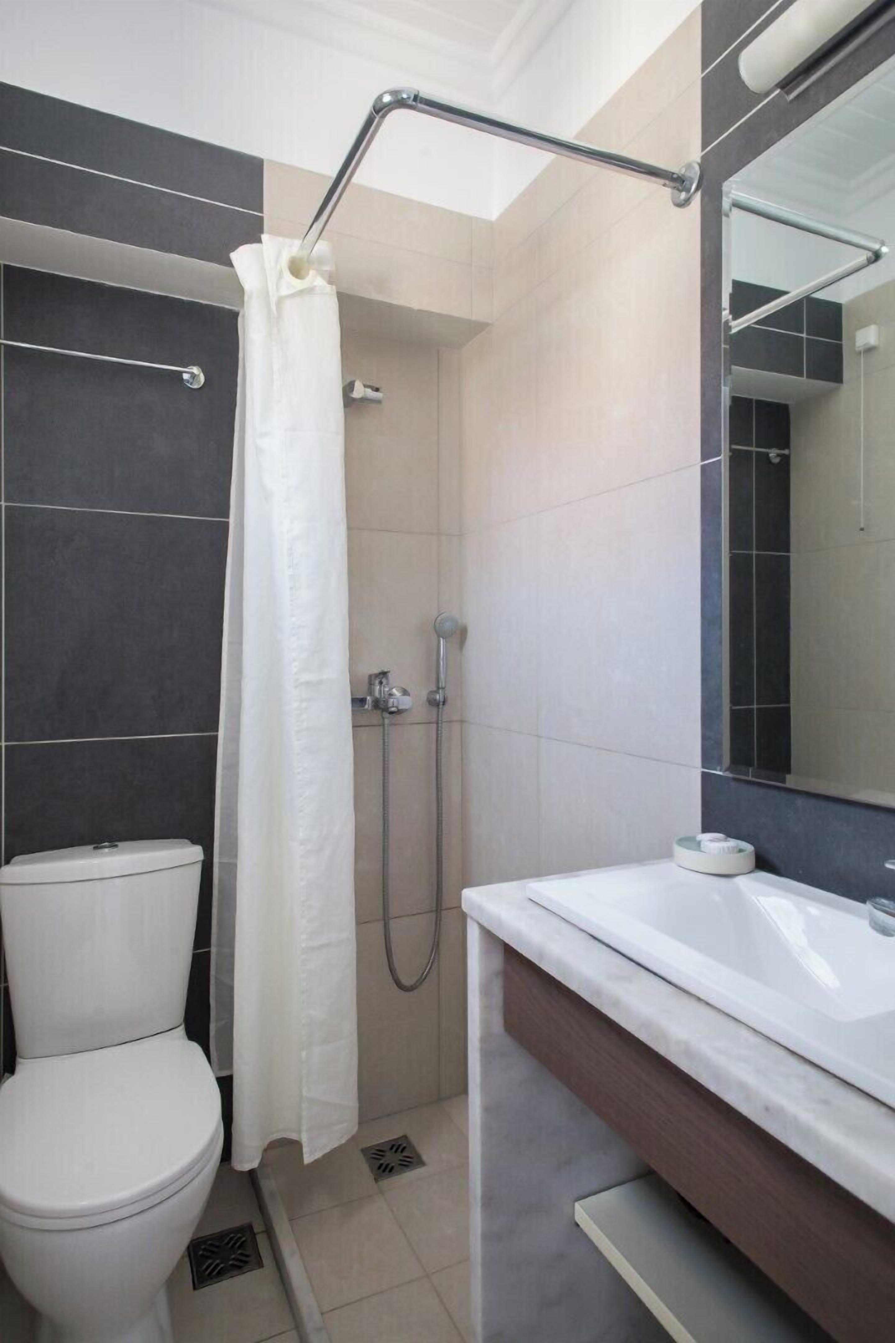 A modern bathroom with a shower, toilet, and sink.