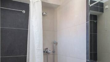 A modern bathroom with a shower, toilet, and sink.