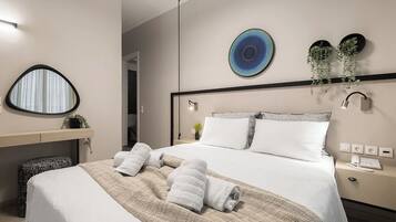 A modern hotel room with a neatly made bed, a bedside table with a lamp, and a wall-mounted plant.