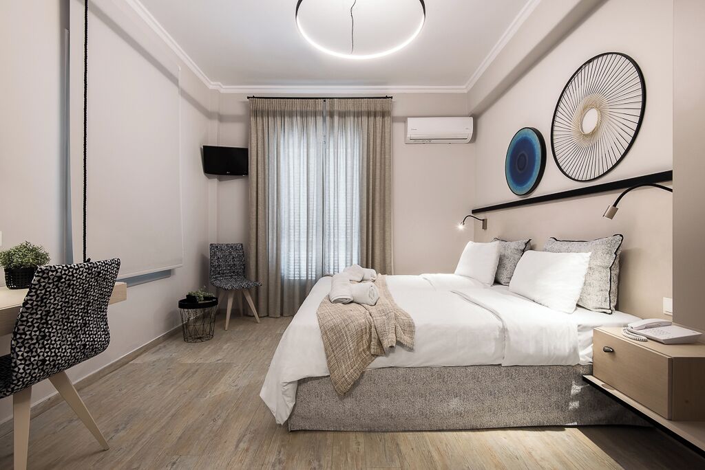 Un dormitorio moderno con cama, mesita de noche y escritorio con silla.
