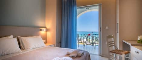 A hotel room with a bed, a desk, a chair, and a balcony with a table and chairs.