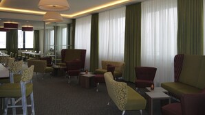 A hotel lobby with a modern design, featuring a mix of seating areas and a dining section. - Hotel am Berg Esslingen (Esslingen)