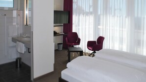 A hotel room with a bed, a desk, a chair, a TV, and a bathroom. - Hotel am Berg Esslingen (Esslingen)
