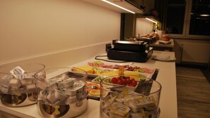 A buffet setup with various food items and condiments. - Hotel am Berg Esslingen (Esslingen)