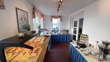 Ein reichhaltiges Buffet mit verschiedenen Speisen und einer Kaffeestation.