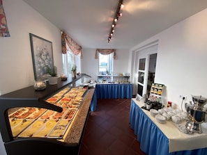 A buffet setup with various food items and a coffee station.