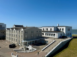 Ein Hotel mit modernem Design, das einen Innenhof, einen überdachten Eingang und Meerblick bietet.