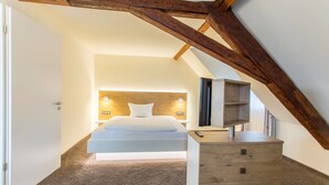 A bedroom with a bed, bedside tables, and a wooden headboard. - Hotel Jägerhaus Esslingen (Esslingen)
