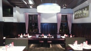 A restaurant with booths and tables, wooden floors, and a chandelier. - Hotel Jägerhaus Esslingen (Esslingen)