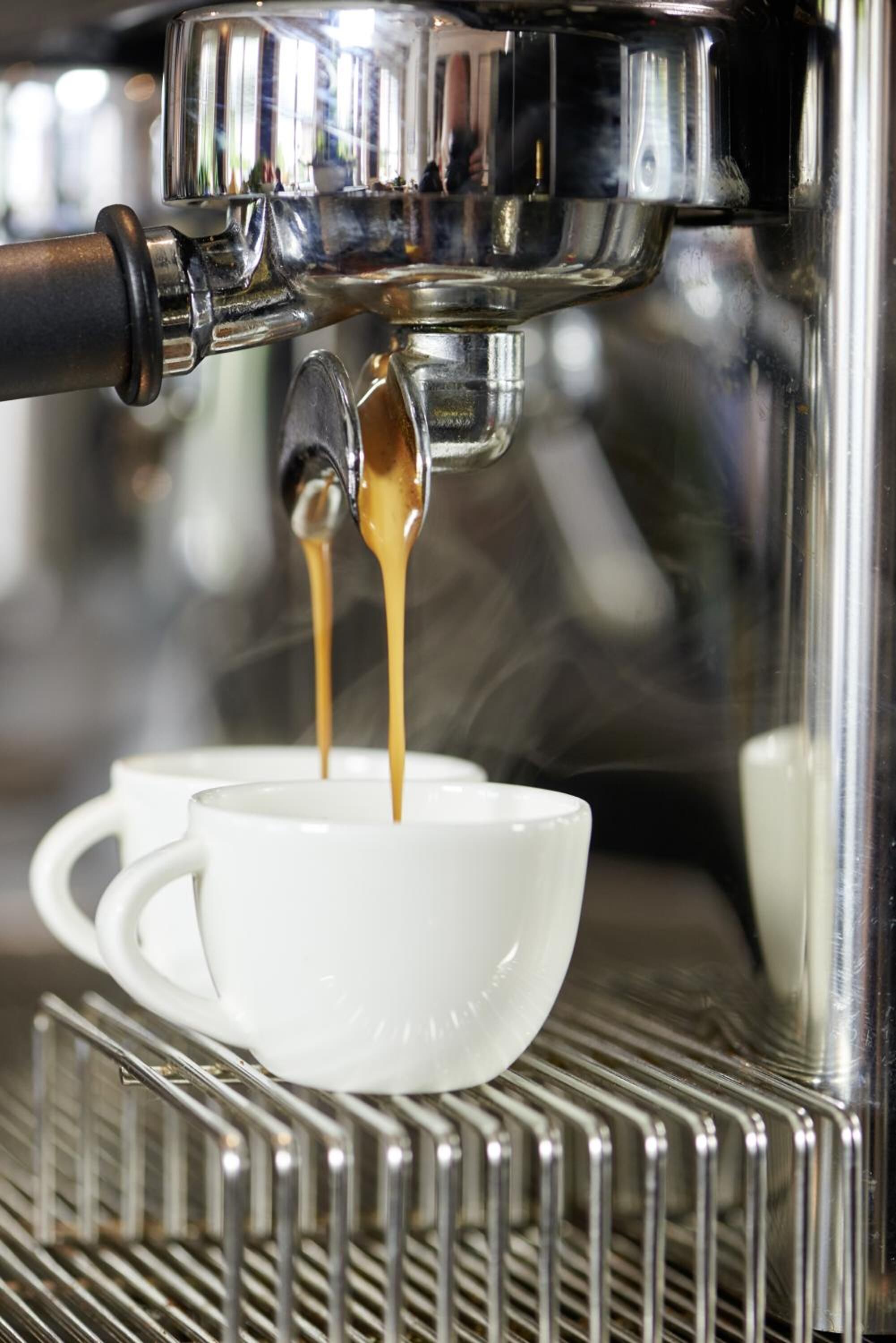 A coffee machine dispensing espresso into a white cup.