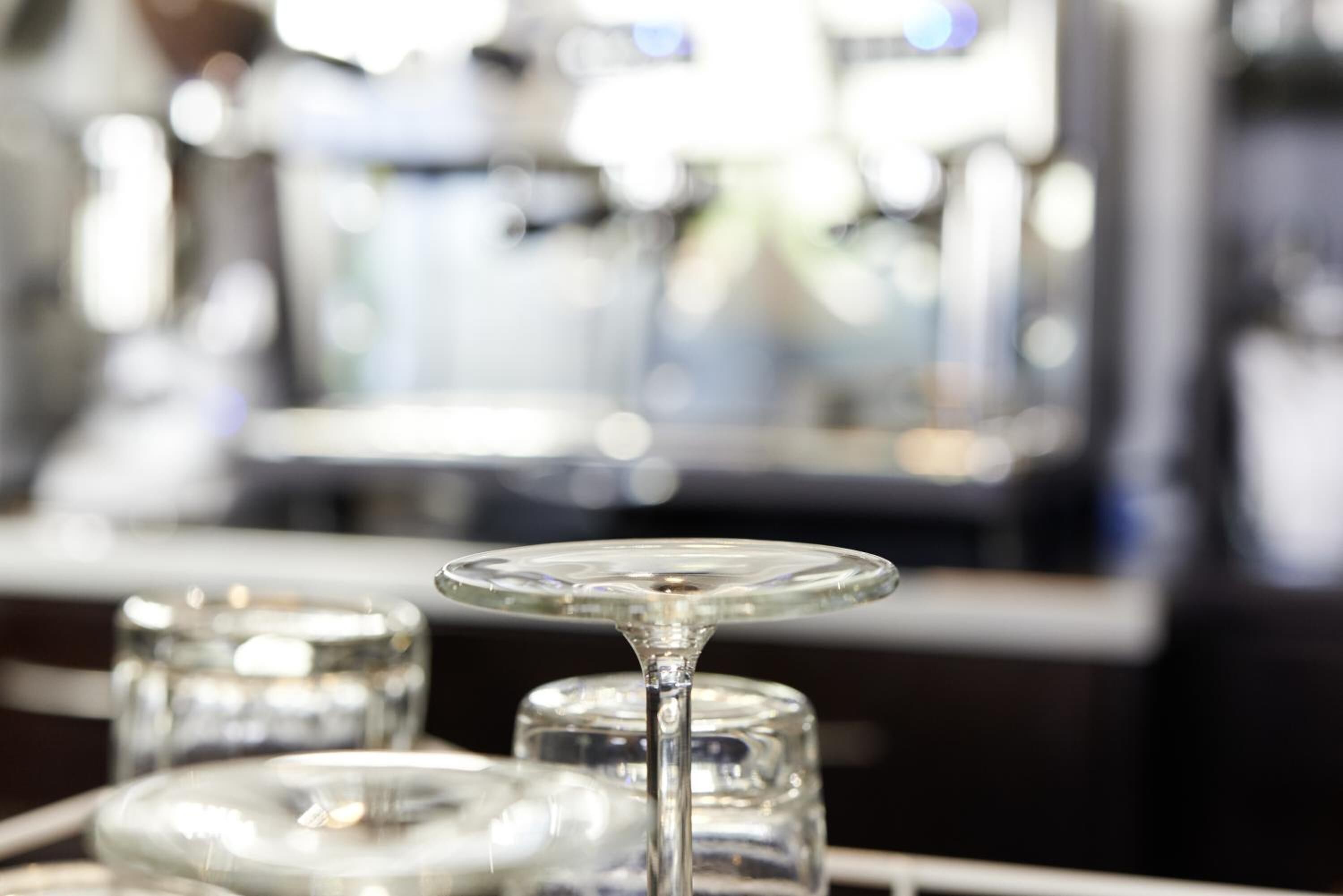 Un bar con una mesa de cristal y un recipiente de vidrio al fondo.