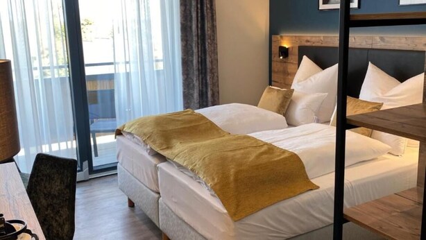 Habitación de hotel con cama, escritorio y una silla.