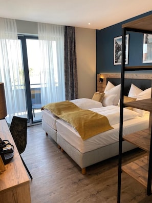 A hotel room with a bed, a desk, and a chair. - Hotel & Restaurant Rizzelli (Neustadt an der Aisch)