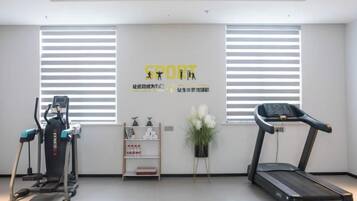 A gym with exercise equipment, a treadmill, and a wall with motivational text.