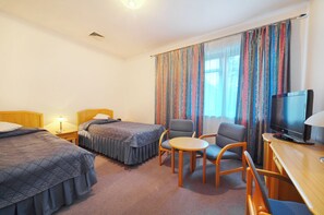 Une chambre d’hôtel avec deux lits, une télévision, une petite table et une chaise.
