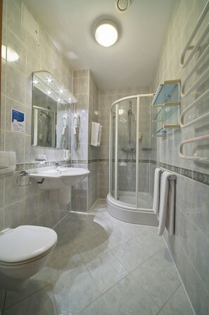 Une salle de bain moderne avec un lavabo, des toilettes et une douche à parois de verre.