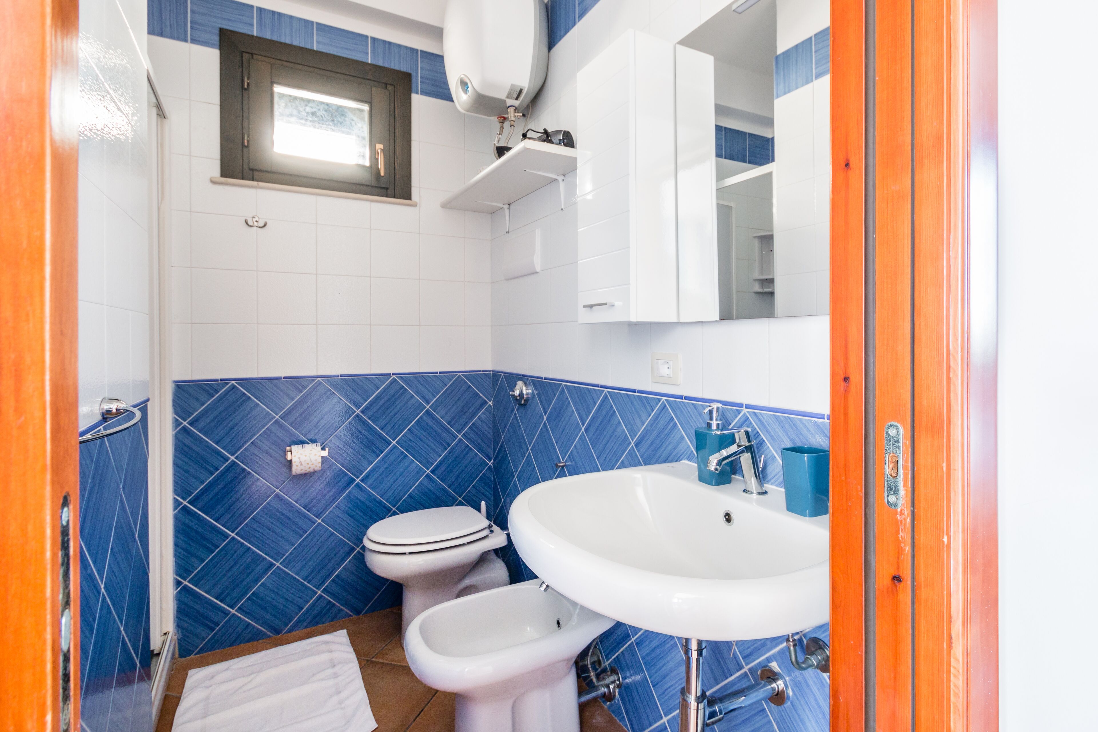 Een badkamer met toilet, hygiëneschuimer en wastafel.