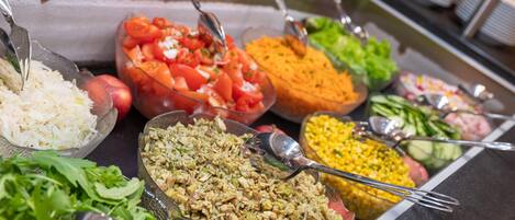 A buffet with various food items including salads, rice dishes, and vegetables.