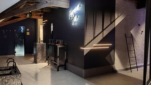 Um interior moderno com área de bar, escada e teto de madeira.