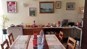 A dining table set with a menu, plates, and water bottles, surrounded by chairs. - B&B Magica Venezia (Mestre)