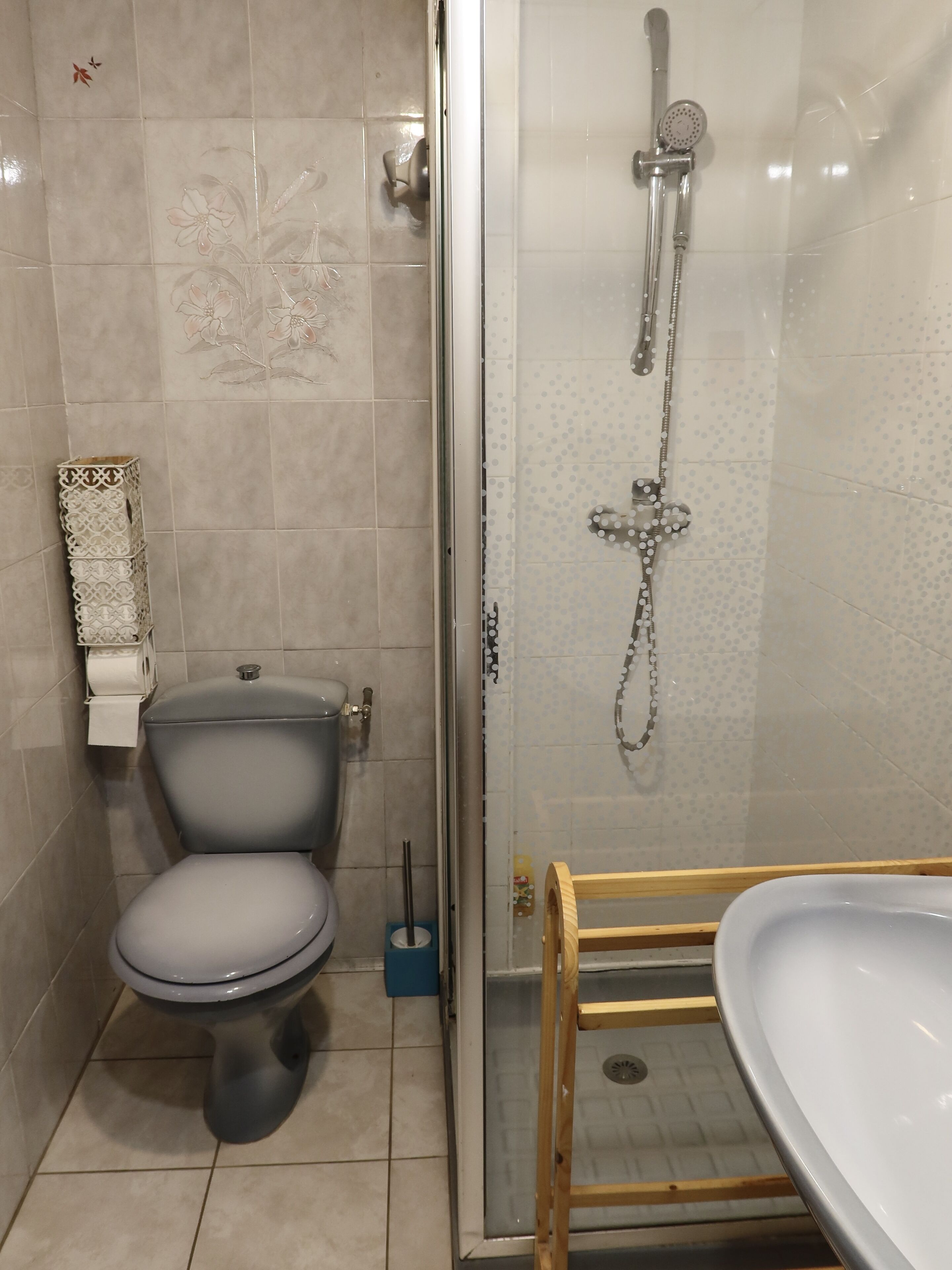 A bathroom with a toilet, a shower enclosure, and a sink.