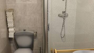 A bathroom with a toilet, a shower enclosure, and a sink.