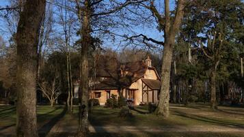 A house surrounded by trees with a clear sky.