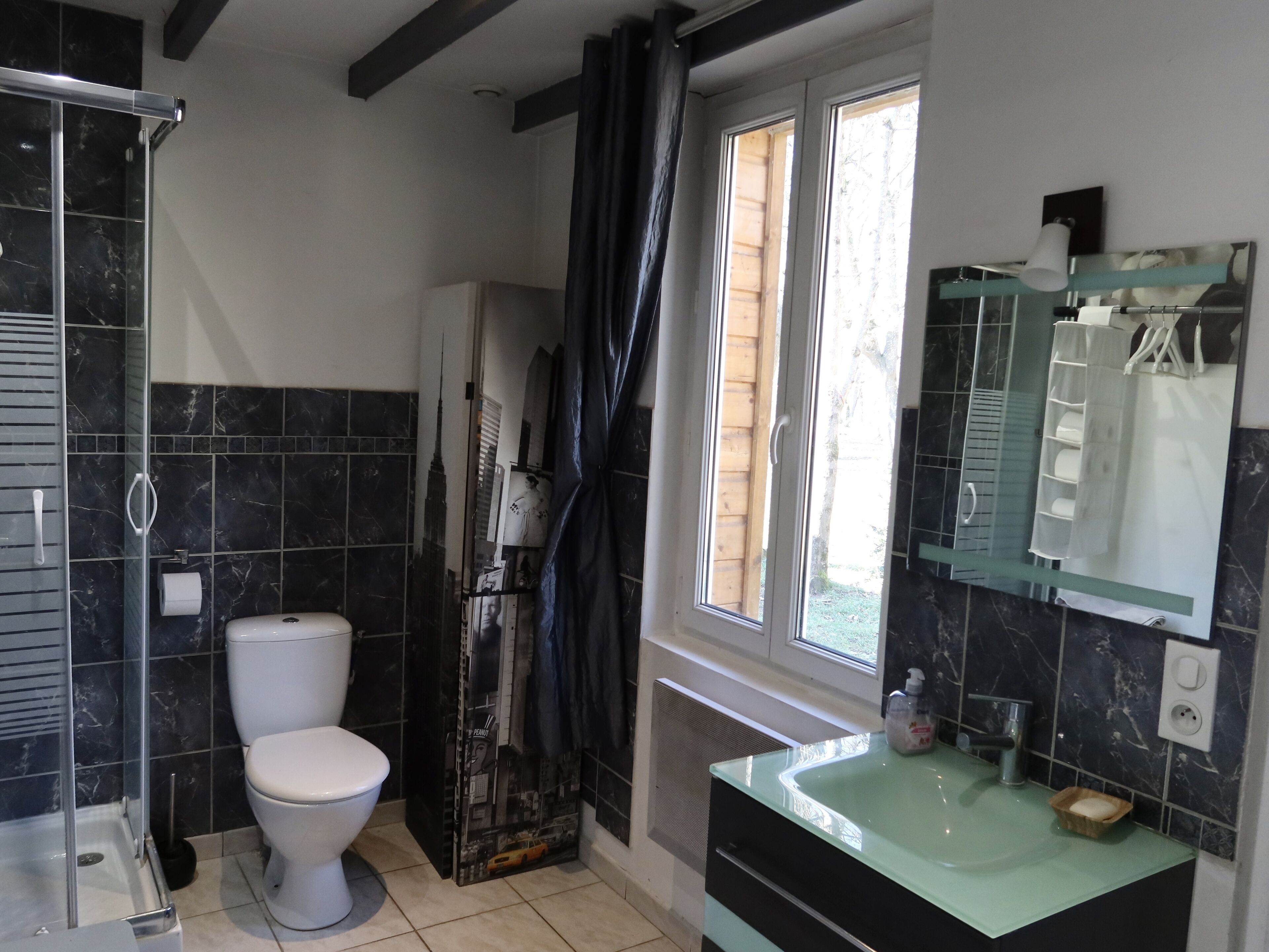 A bathroom with a toilet, shower, and sink.
