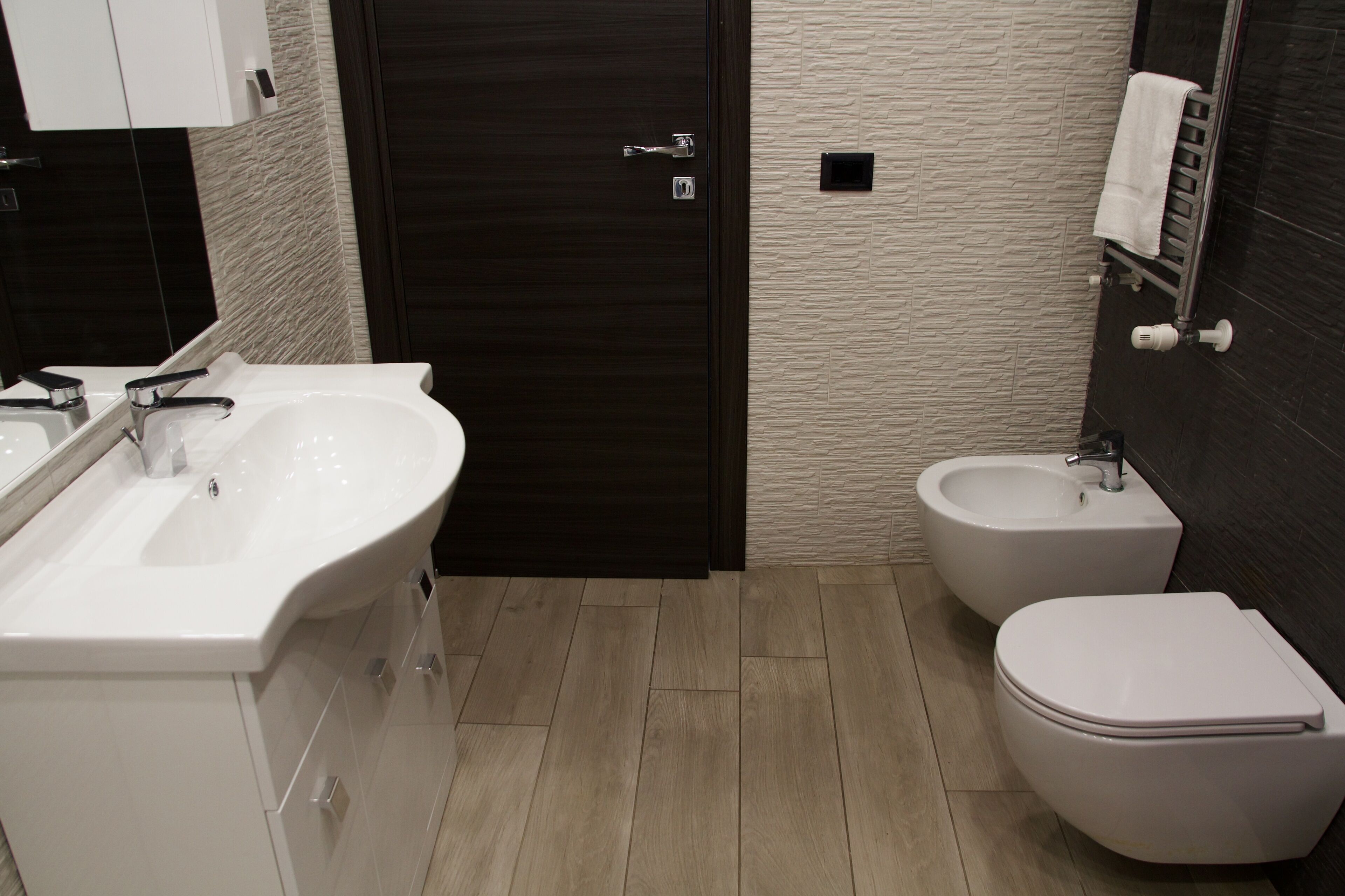 Un baño moderno con lavamanos doble, un bidé y un inodoro.