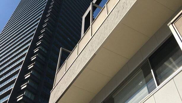 Un edificio moderno con fachada de vidrio destacada y techo plano.