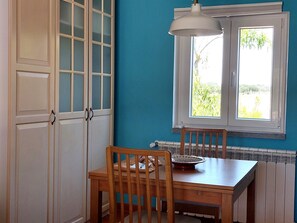 A room with a table, chairs, a window, and a radiator.