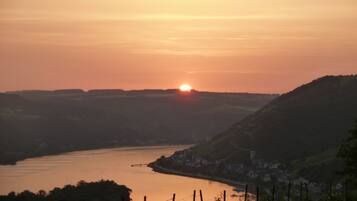 A sunset over a river with hills on either side.