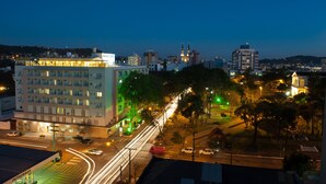 Un hotel con varios pisos, un estacionamiento y una calle con semáforos.