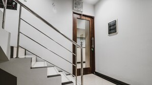 Eine Treppe mit Metallgeländer, die zu einer Tür mit Glasscheibe führt.