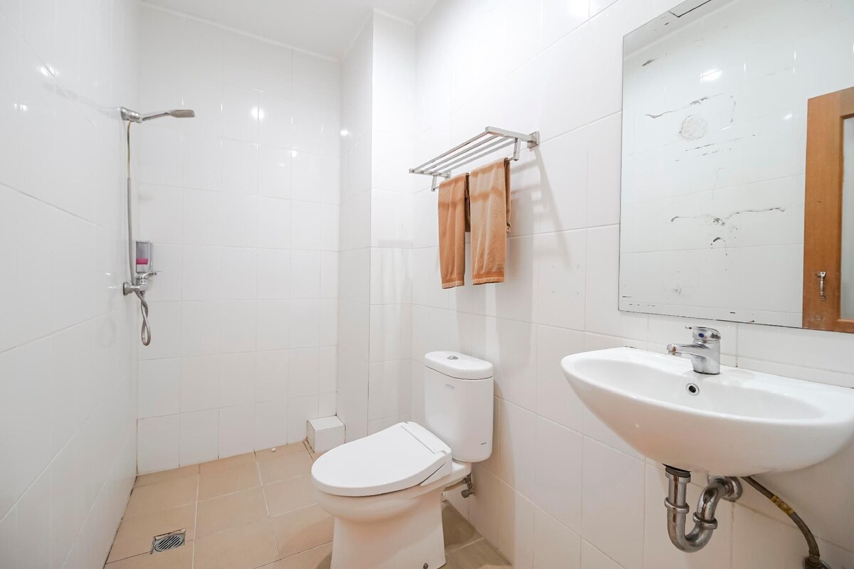 A bathroom with a toilet, sink, and shower.