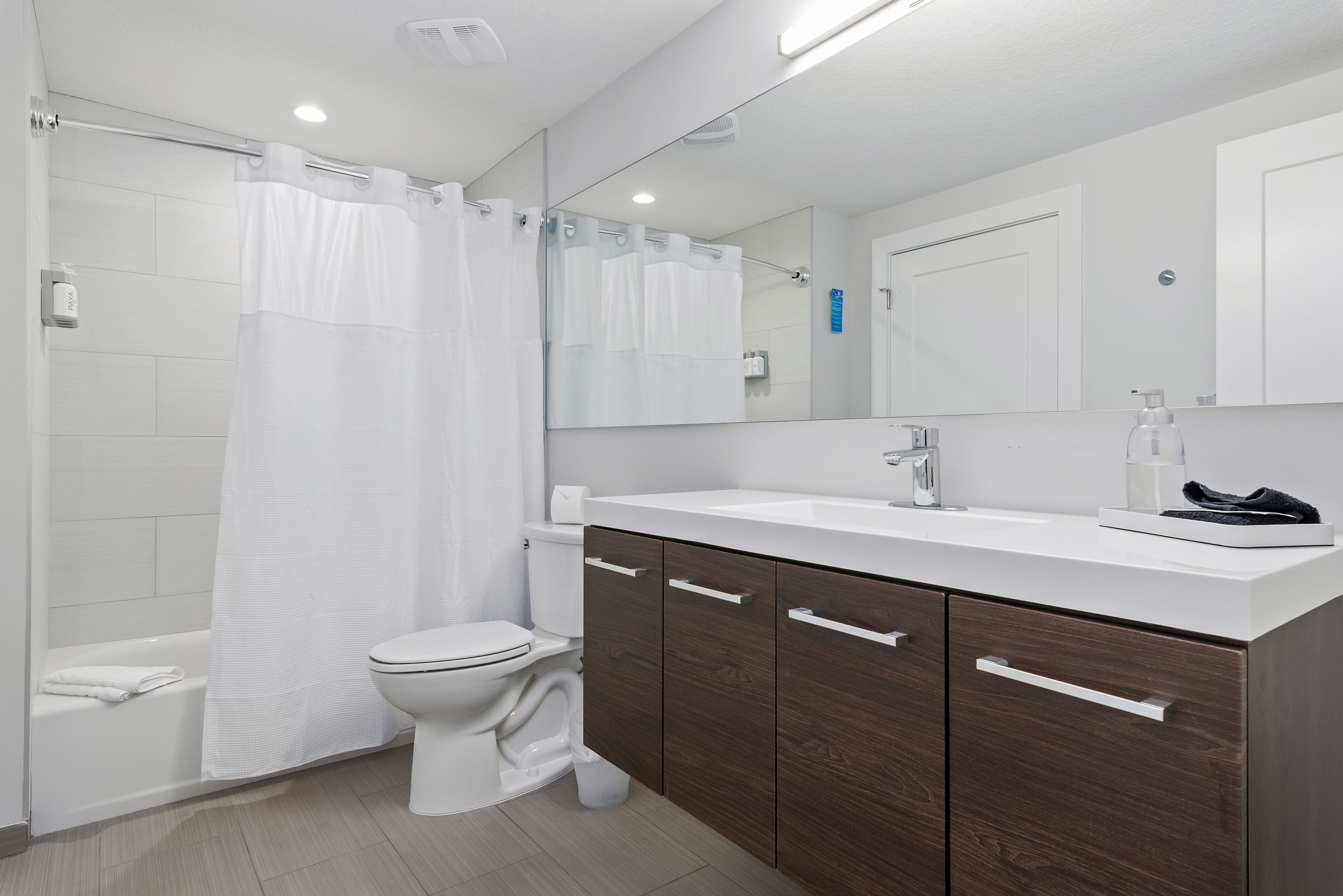 A modern bathroom with a shower, toilet, and vanity.