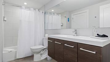 A modern bathroom with a shower, toilet, and vanity.