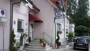 A building with a sign reading 'Müblenstüble' and a restaurant sign above the entrance.