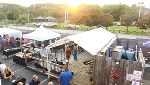 An outdoor event with food stalls and a stage with musical equipment. - Seagrass Inn (Old Orchard Beach)