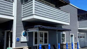 A Seagrass Inn office building with a 10-minute parking sign, outdoor seating, and a garage. - Seagrass Inn (Old Orchard Beach)