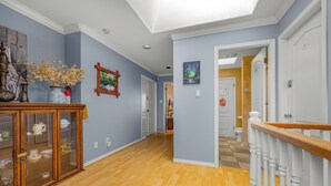 A hallway with wooden flooring, a glass cabinet, and a staircase with a wooden handrail. - Charming Family Hotel (Richmond)